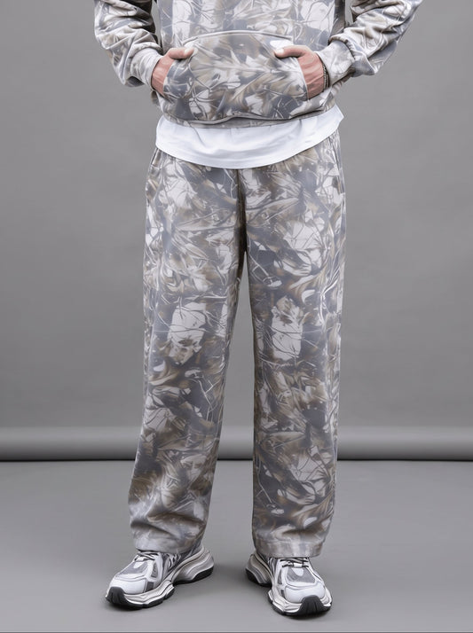 Person wearing a camouflage tracksuit on a gray background